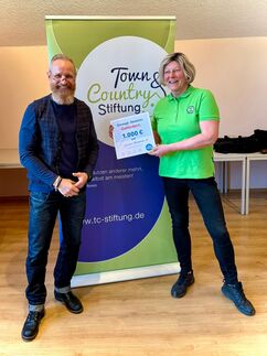 Thomas Brechel übergibt Scheck an Verein